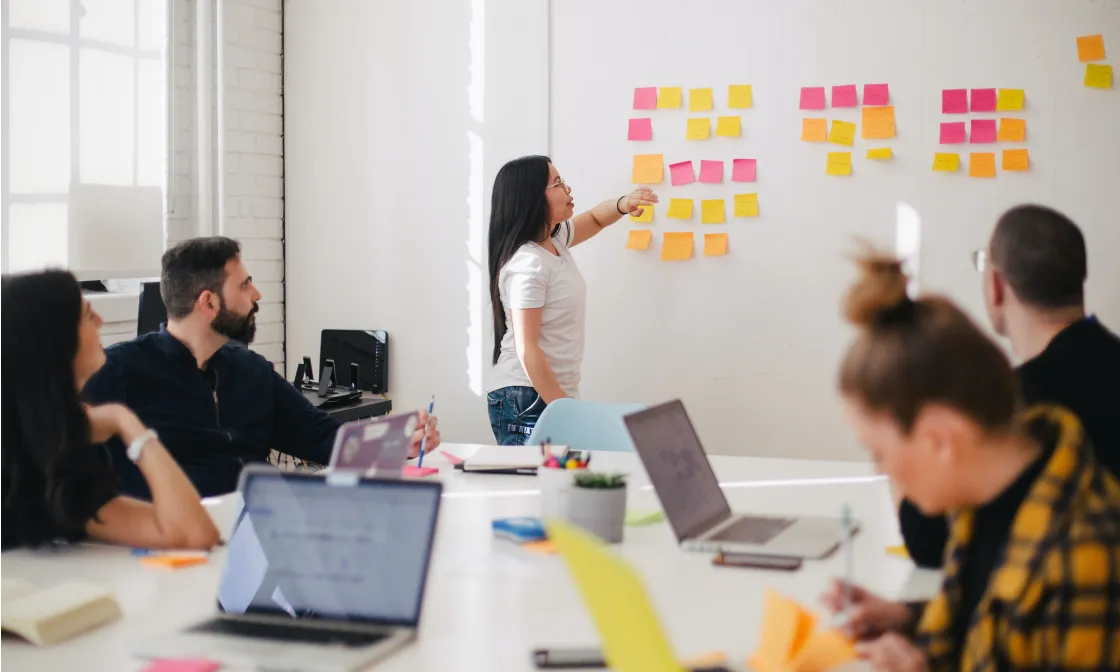 Pendo team member adding sticky notes to a whiteboard